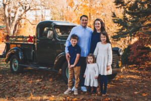 family of five smiling in front of a green holiday truck along the Yardley Canal