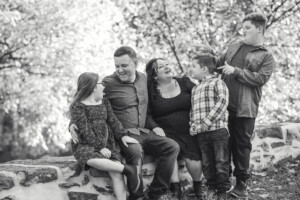 Family in black and white laughing and enjoying quality time at Shofield Covered Bridge in Bucks County