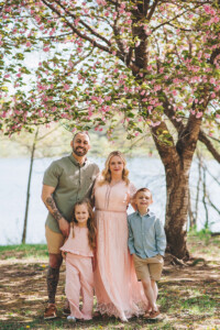 Family of four smiling together during a spring portrait session at Core Creek Park in Bucks County