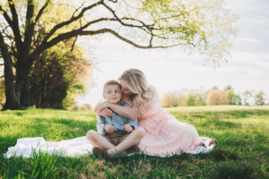 Son surprised by Mom's kiss during an outdoor family portrait session in Bucks County
