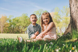 Young siblings hugging and laughing during a playful Bucks County family photography session