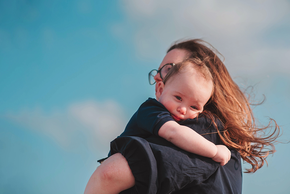 little boy being carried on his Mom's shoulder along the jersey shore