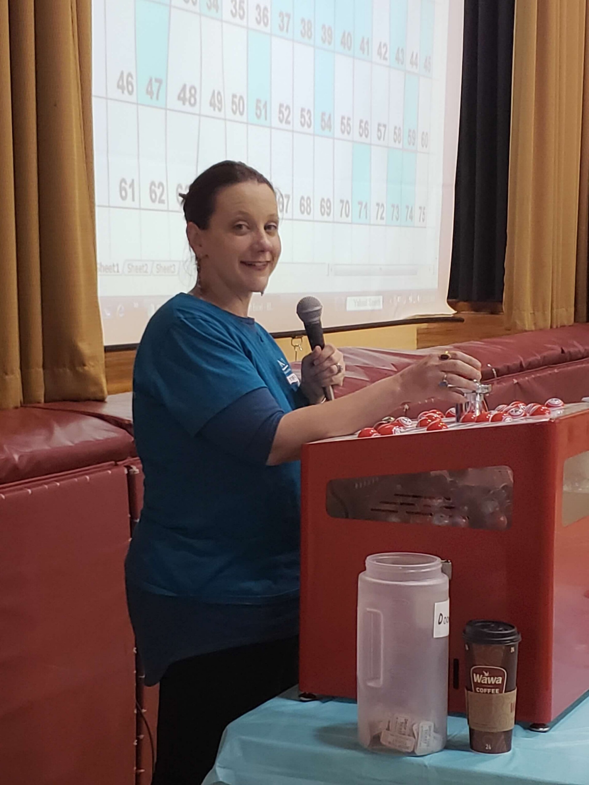 Tiff using the Bingo machine while calling numbers at the Makefield Women’s Association Designer Bag Bingo fundraiser.