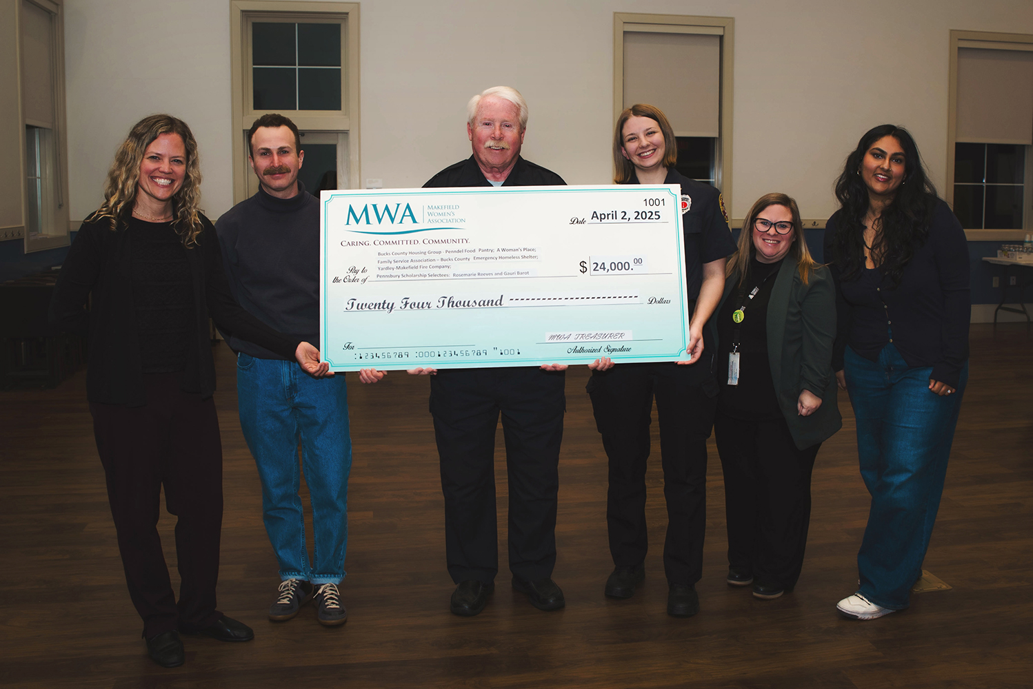 Makefield Women’s Association beneficiaries holding a large donation check at the annual check presentation