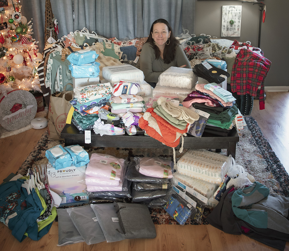 Tiff surrounded by new clothing collected for a Christmas donation to Fostering Hope Philly-NE.