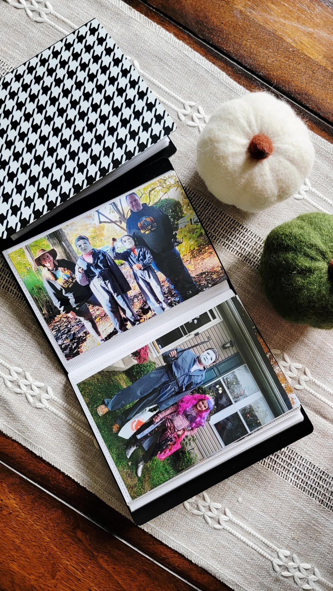Halloween memory albums open to yearly costume photos of the kids, surrounded by cozy fall decor.